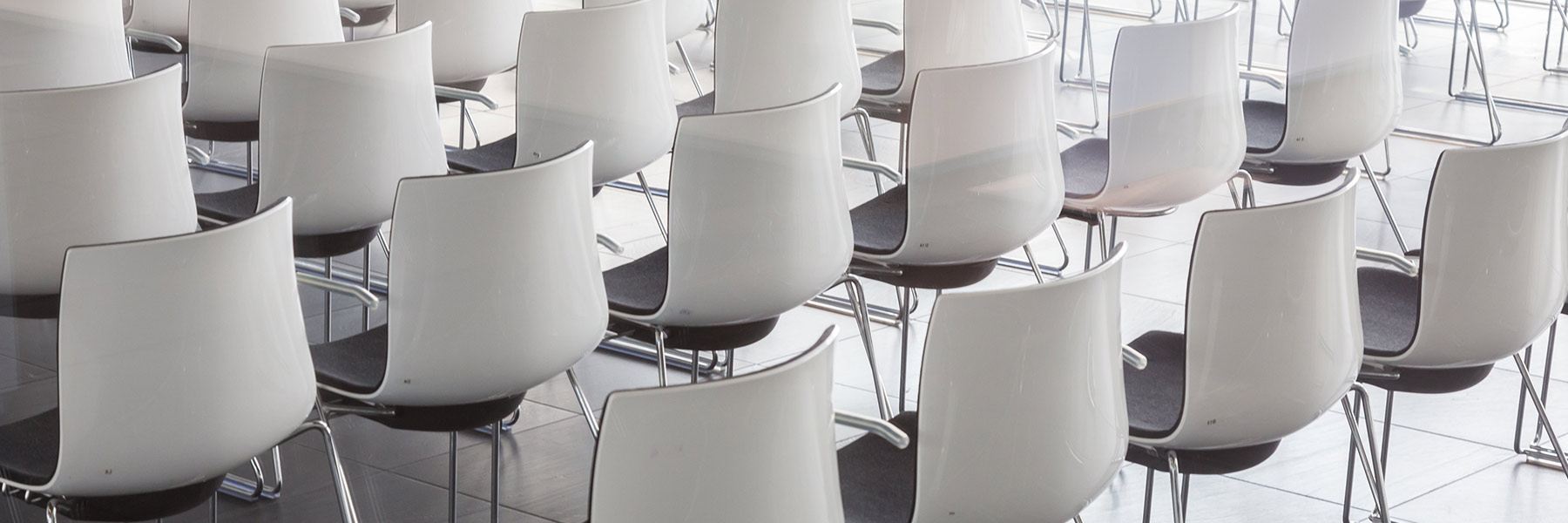 Room full of empty white chairs.